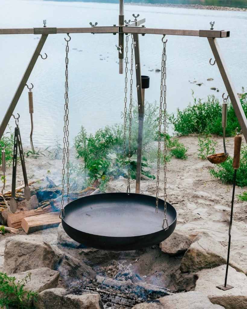 Große Pfanne an Ketten über der Feuerstelle am Strand
